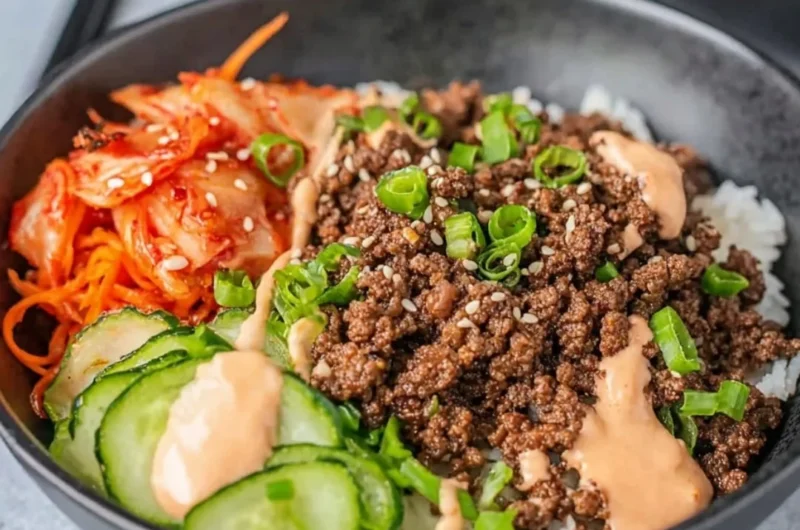 Korean Beef Rice Bowl topped with fresh vegetables and garnished with sesame seeds