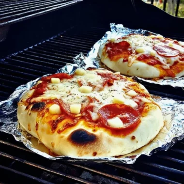 Delicious grilled pizza with fresh toppings on a barbecue grill