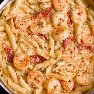 Delicious creamy shrimp pasta garnished with herbs in a bowl
