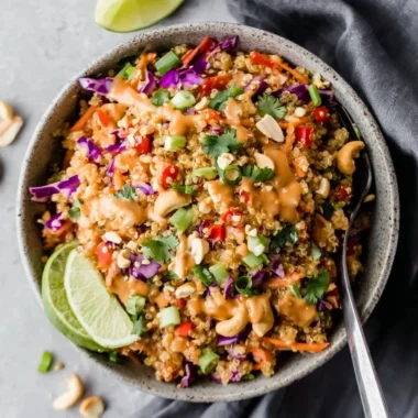 Colorful Thai quinoa salad topped with peanut ginger dressing and fresh vegetables.