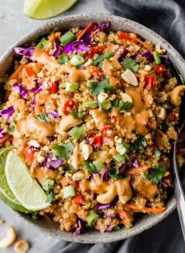 Colorful Thai quinoa salad topped with peanut ginger dressing and fresh vegetables.