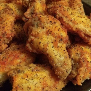 Delicious easy lemon pepper chicken wings garnished with lemon slices and herbs
