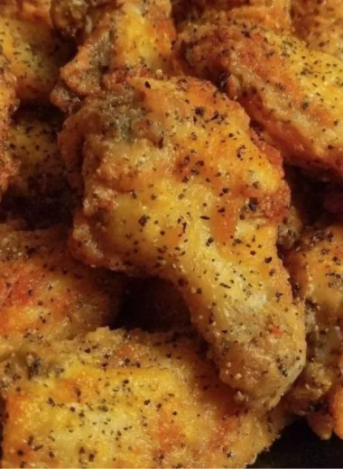 Delicious easy lemon pepper chicken wings garnished with lemon slices and herbs