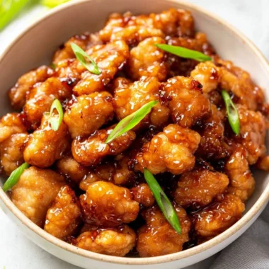 Plate of crispy Honey Butter Chicken drizzled with honey and butter sauce.