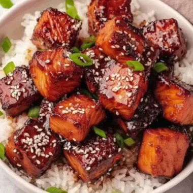 Honey Garlic Salmon Bites Bowl garnished with vegetables and sesame seeds.