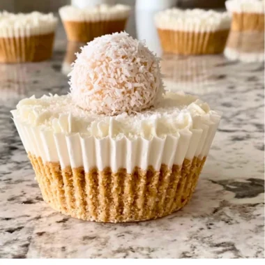 Delicious no-bake coconut cheesecake served on a white plate with coconut flakes