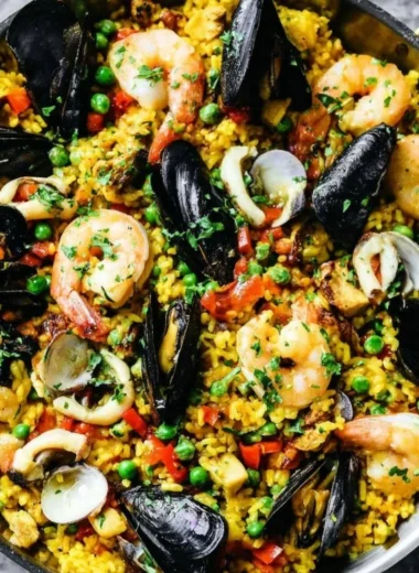 Delicious authentic paella with seafood and vegetables served in a traditional pan