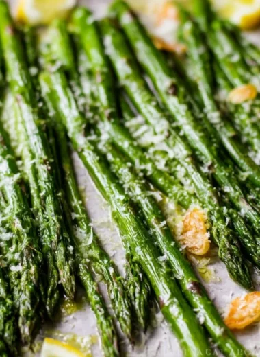 Oven roasted garlic parmesan asparagus on a plate garnished with herbs.