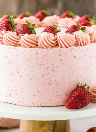 Homemade strawberry cake topped with fresh strawberries and cream.