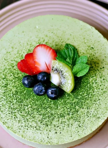 No-bake Matcha Cheesecake topped with matcha powder and fresh berries