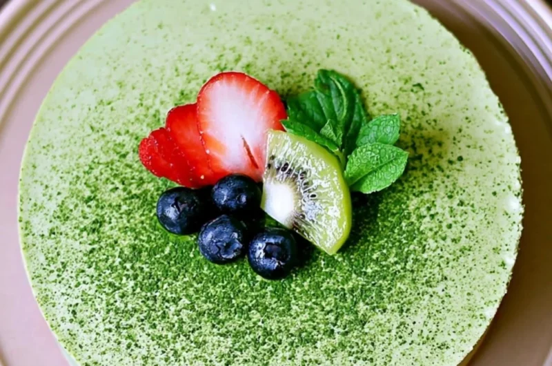 No-bake Matcha Cheesecake topped with matcha powder and fresh berries