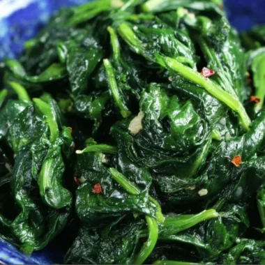 Plate of quick and easy sautéed spinach seasoned with garlic and olive oil