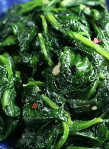 Plate of quick and easy sautéed spinach seasoned with garlic and olive oil