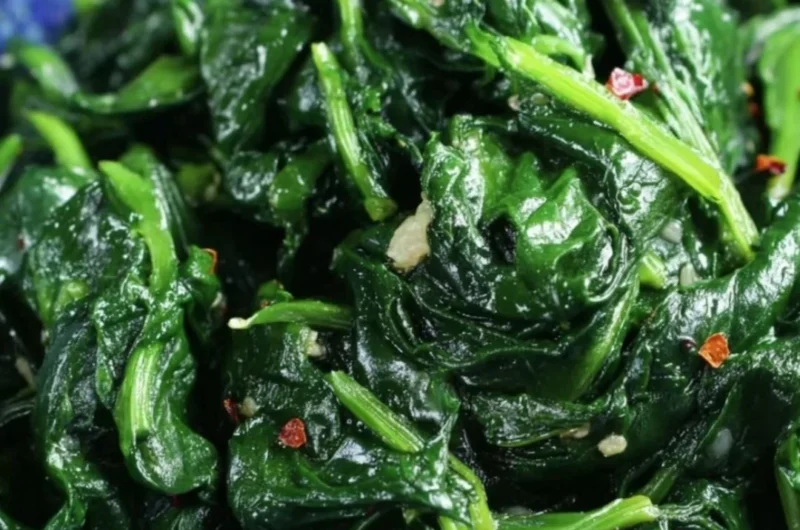 Plate of quick and easy sautéed spinach seasoned with garlic and olive oil