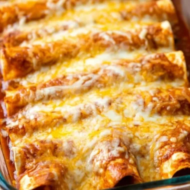 Delicious restaurant-style red cheese enchiladas topped with sauce and cheese