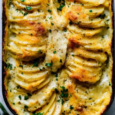 Creamy scalloped potatoes baked to perfection in a casserole dish.