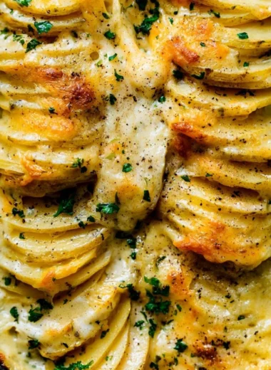 Creamy scalloped potatoes baked to perfection in a casserole dish.