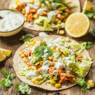 Skinny Buffalo Chicken Tacos topped with fresh ingredients and served in a tortilla.