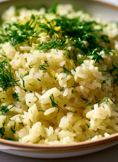 Plate of Authentic Greek Lemon Rice garnished with fresh herbs