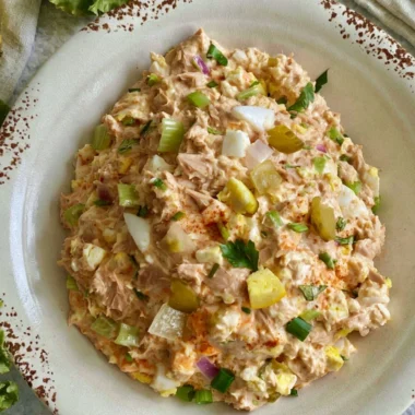 Delicious tuna salad with eggs served in a bowl, garnished with herbs.