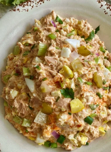 Delicious tuna salad with eggs served in a bowl, garnished with herbs.
