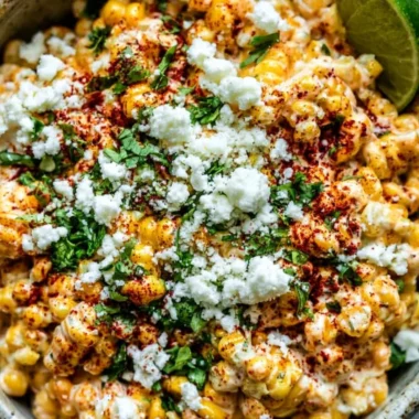 Delicious Mexican street corn (Elote) served on a cob with toppings