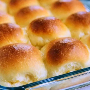 Plate of warm, golden brown old fashioned yeast rolls, fresh out of the oven.