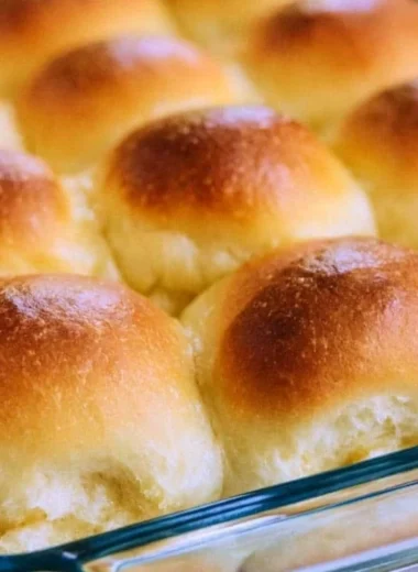 Plate of warm, golden brown old fashioned yeast rolls, fresh out of the oven.