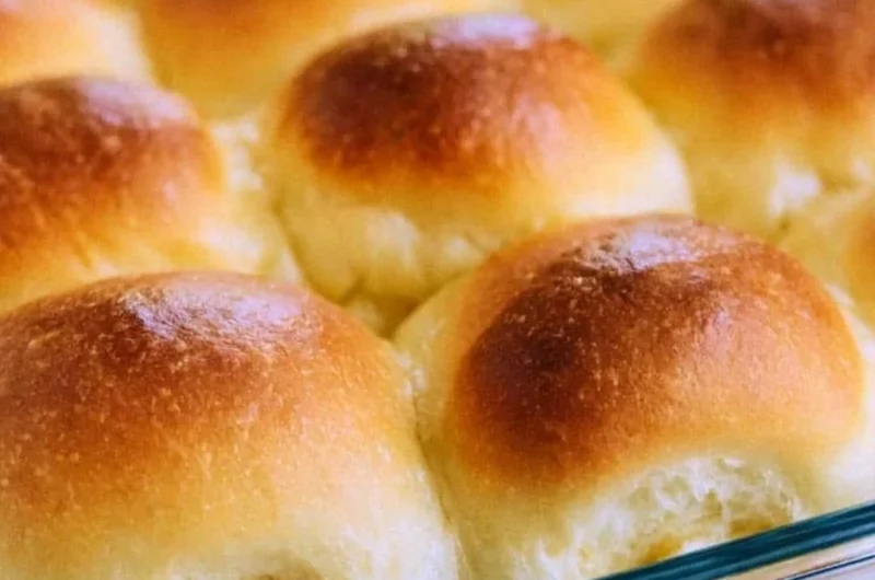 Plate of warm, golden brown old fashioned yeast rolls, fresh out of the oven.