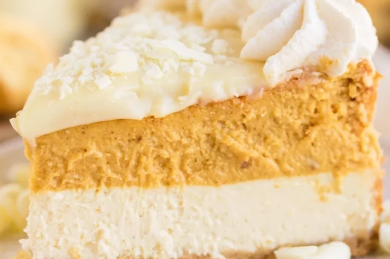 A delicious slice of cozy eggnog pumpkin cheesecake topped with whipped cream.