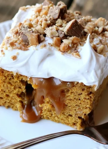 Deliciously moist caramel pumpkin poke cake topped with whipped cream and caramel drizzle.