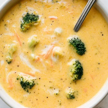 Bowl of creamy broccoli cheddar soup garnished with fresh herbs