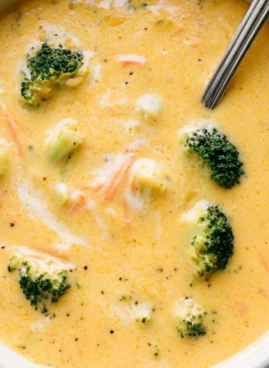 Bowl of creamy broccoli cheddar soup garnished with fresh herbs