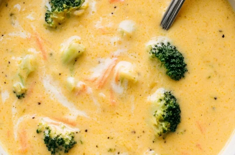 Bowl of creamy broccoli cheddar soup garnished with fresh herbs