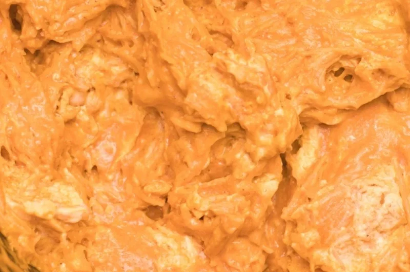Creamy and spicy Crockpot Buffalo Chicken Dip served in a bowl with tortilla chips.