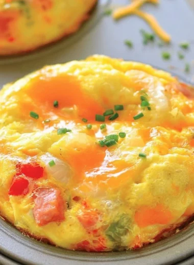 Denver omelet muffins baked in a muffin tin, featuring bell peppers, onions, and cheese.