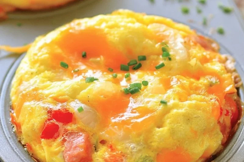 Denver omelet muffins baked in a muffin tin, featuring bell peppers, onions, and cheese.